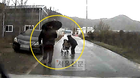 전씨가 지난 11일 오후 3시쯤 청주시 흥덕구 오송읍 공복리의 시골길에서 비를 맞고 걸어가는 할머니에게 우산을 건네기 위해 뛰어가고 있다. [사진=전희룡씨 제공]