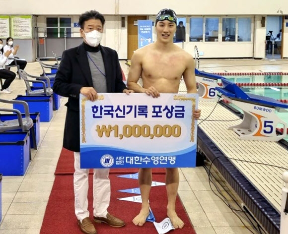 25일 제16회 제주한라배 전국수영대회 남자 일반부 평영 50m에서 27초 09의 한국 신기록으로 우승한 최동열(오른쪽)이 포상금 100만원을 받은 뒤 기념촬영을 하고 있다. 대한수영연맹 제공