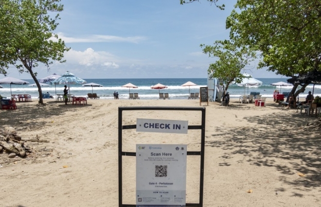 적막한 인도네시아 발리 해변 2021년 11월 25일 인도네시아 발리 섬 쿠타 해변에 신종코로나바이러스감염증(코로나19) 감시앱 설치를 권고하는 팻말이 세워져 있다. EPA 연합뉴스