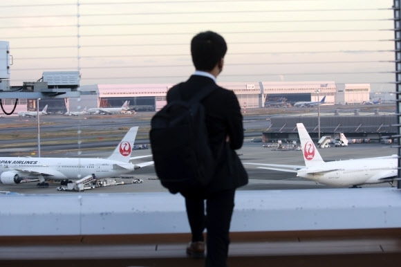 지난달 29일 일본 도쿄의 관문인 나리타 국제공항 탑승장에서 활주로를 바라보는 한 남성.  AP 연합뉴스   