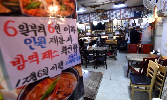 방역 패스 적용시설이 대폭 확대된 6일 서울 중구의 한 식당에서 주인이 손님을 받기 위해 테이블을 정리하고 있다. 2021.12.6 박지환기자 popocar@seoul.co.kr