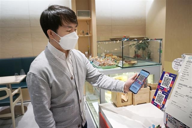 서울 강서구의 한 구민이 지역의 제로페이 가맹점에서 스마트폰에 저장된 서울강서사랑상품권을 이용하고 있다. 강서구 제공