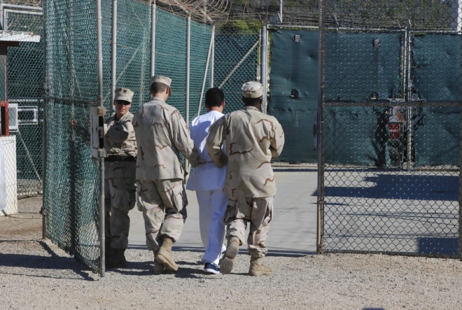 미해군 간수들이 2008년 관타나모 섬의 미군 기지 수용소에서 한 수감자가 심문을 마친 뒤 데려가고 있다. 로이터 자료사진 