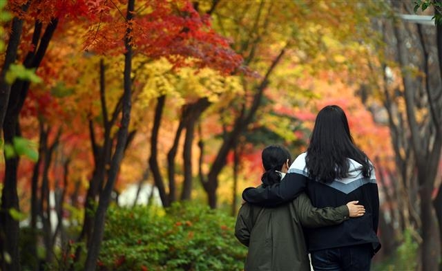 지난해 성별 정정을 마친 윤슬(오른쪽·가명)씨와 윤슬씨의 어머니 김수현(가명)씨가 지난달 19일 서울 구로구의 한 가로수길에서 서로를 보듬으며 걸어 가고 있다. 정연호 기자 tpgod@seoul.co.kr