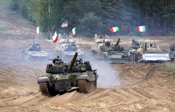우크라이나와 러시아 국경 지대의 군사적 긴장감이 고조되는 가운데 13일(현지시간) 라트비아 카다가의 훈련장에서 열린 나토(북대서양조약기구)의 대규모 군사 훈련 ‘나메즈 2021’에 미국·이탈리아·폴란드 등 군용 차량이 참여하고 있다. 카다가 AP 연합뉴스