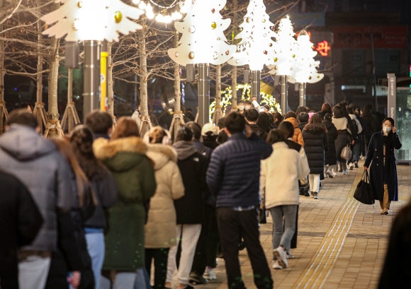 성탄 트리 조명 아래 선별진료소 대기