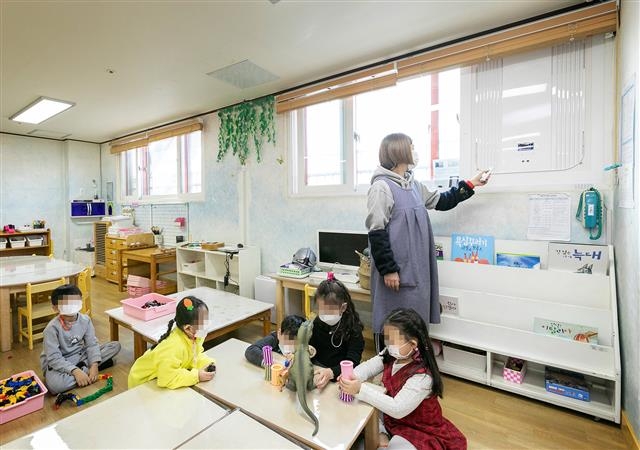 서울 강서구의 한 어린이집 보육교사가 최근 설치된 창문 환기형 공기정화 시스템을 조작하고 있다. 강서구 제공