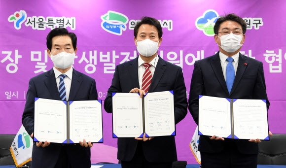 오세훈(가운데) 서울시장과 오승록(오른쪽) 노원구청장, 안병용 경기 의정부시장이 22일 서울시청에서 차세대 바이오메디컬 복합단지 조성을 위한 협약을 체결한 뒤 기념 촬영을 하고 있다. 연합뉴스