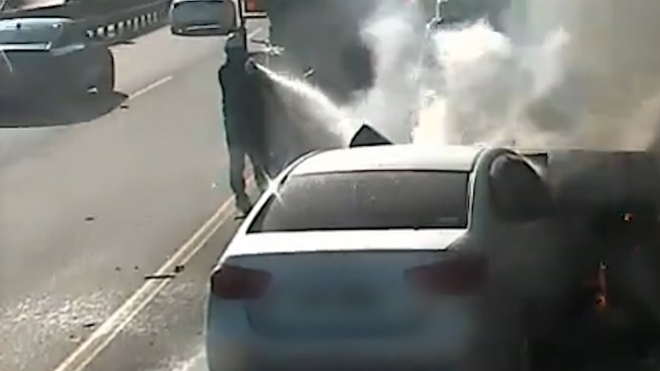 지난 17일 울산 울주군의 자동차전용도로에서 발생한 화재를 레미콘 기사가 진화하고 있다. 울주소방서 제공.