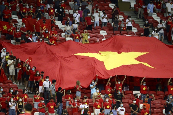 베트남 서포퍼들이 지난 23일 싱가포르에서 열린 아세안축구연맹(AFF)스즈키컵 준결승 1차전에서 대형 국기를 흔들며 자국 선수들을 응원하고 있다. [AP 연합뉴스]