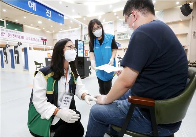 서울 성동구가 지난 10월까지 운영한 백신접종센터에서 구 관계자가 장애인 백신접종 대상자와 대화를 나누고 있다. 성동구 제공