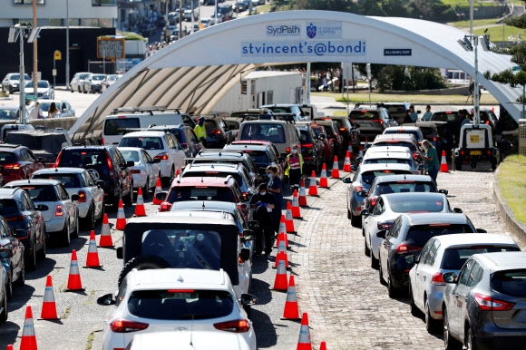 30일 호주 시드니에서 코로나19 검사를 받기 위한 사람들로 검사소에 긴 차량 행렬이 늘어서 있다. ‘방역 모범국’으로 꼽혀온 호주는 최근 코로나19 확진자 수 폭증을 겪고 있다. 시드니 로이터 연합뉴스