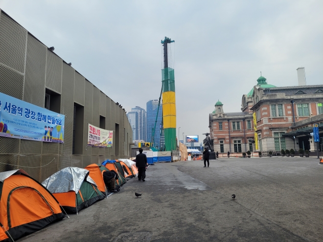 지하철 1호선 서울역 1번과 2번 출구 사이 광장 양옆으로 지난달 29일 텐트 20여개가 나란히 서 있다. 노숙인들의 한파 대비와 코로나 방역을 위한 임시 조치로 교회나 시민단체 등에서 마련한 것이다.