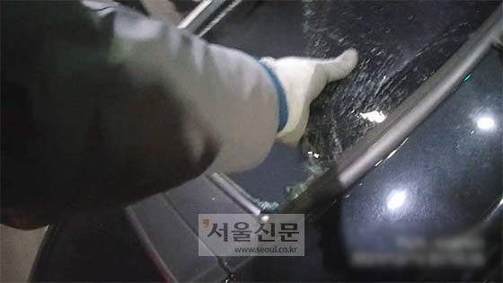 박석홍 경사가 전도된 승용차 안에 갇힌 운전자를 구조하기 위해 유리창을 손으로 뜯어내고 있다. [광주경찰청 제공]