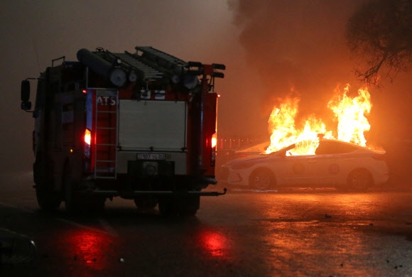 4일(현지시간) 카자흐스탄 알마티에서 액화석유가스(LPG) 가격상한제 해제에 항의하는 대규모 시위가 열린 가운데 시위대가 방화한 경찰차가 불타고 있다. 알마티 로이터 연합뉴스