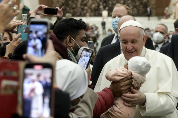 프란치스코 교황이 5일(현지시간) 바티칸 수요 일반 알현 도중 한 신도가 갓난 아기에 축복을 내려달라고 하자 반가워하고 있다. 바티칸시티 AFP 연합뉴스 