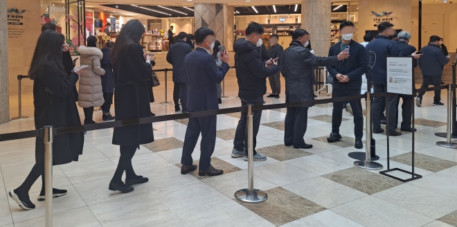 서울 중구의 한 백화점을 이용하는 시민들이 코로나19 방역패스 대형 점포 의무 적용 첫날인 10일 오전 11시쯤 QR코드로 접종 정보를 인증하려고 줄을 서서 기다리고 있다.