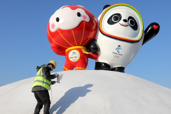 베이징 동계올림픽이 다음날 4일 개막되는 가운데 지난 11일 중국 베이징에서 한 노동자가 올림픽 마스코트인 빙둔둔(오른쪽)과 패럴림픽 마스코트인 쉐룽룽 근처에서 페인트 작업을 하고 있다. 베이징 EPA 연합뉴스