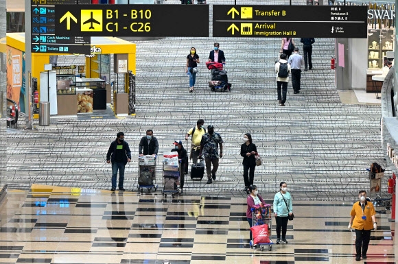 싱가포르 공항 풍경 싱가포르 창이 국제공항을 이용하는 여행객들. 2022.1.12  AFP 연합뉴스