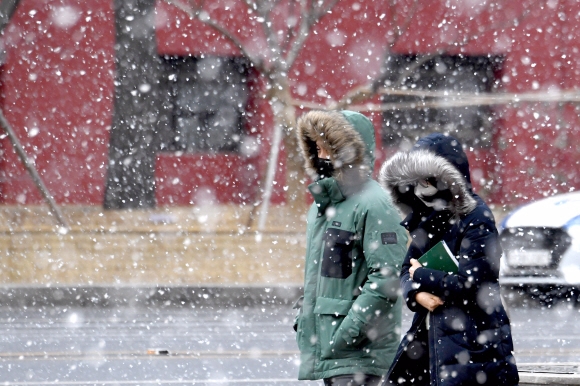 흰 눈 사이로  한 시민이 17일 눈발이 날리는 서울 거리를 걸어가고 있다. 기상청은 이날 수도권과 강원영서·충청·전북·경북북부·제주 등을 중심으로 18일 오전까지 1㎝가량의 눈이 쌓이겠다고 밝혔다. 18일 최저기온이 영하 16도에서 영하 3도로 예보되는 등 이번 주에도 한파가 이어질 예정이다. 박지환 기자