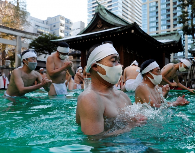 코로나19 극복 기원하는 냉수욕 행사 9일 일본 도쿄의 한 신사에 새해를 맞아 냉수욕을 통해 영혼을 정화하고 코로나19 극복을 기원하는 행사가 열리고 있다. 2022.1.9.  로이터 연합뉴스