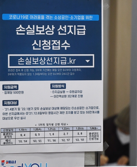 19일 소상공인 손실보상 500만원 선지급 온라인 신청 접수 시작 첫날 종로 소상공인시장진흥공단에 일상회복자금 약정을 히기위해 찾은 소상공인들이 서류를 작성하고 있다. 2022.1.19안주영 전문기자