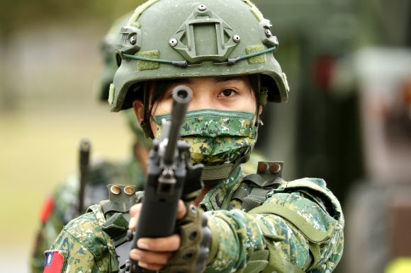 한 대만군 병사가 21일(현지시간) 대만 타이둥의 한 군사기지에서 차이잉원 대만 총통의 방문 중 총을 들고 있다. 차이잉원 총통은 중국과 대만의 군사적 긴장이 고조되는 가운데 대만의 방위력을 강화하겠다고 약속했다. EPA 연합뉴스