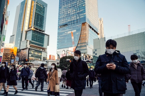 일본에서 지난 21일(현지시간) 마스크를 쓴 사람들이 도쿄 시내를 걷고 있다. 도쿄 신화 연합뉴스