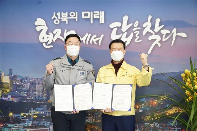 서울 성북구가 전기통신금융사기 피해 예방을 위해 경찰, 구의회, 금융기관과 업무협약을 맺었다. 사진은 이승로(오른쪽) 성북구청장과 김문영 종암경찰서장이 협약을 맺은 뒤 기념 촬영을 하는 모습. 성북구 제공