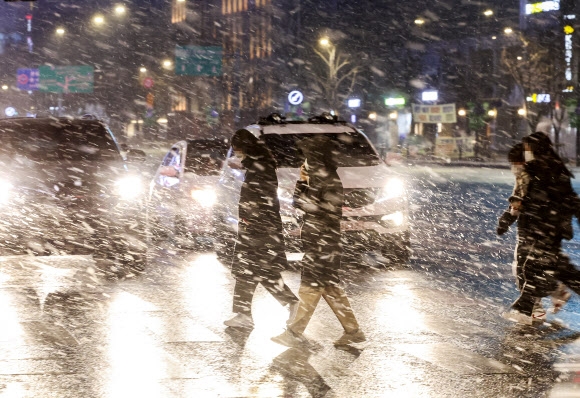 31일 저녁 서울 세종로사거리에 눈이 내리고 있다. 기상청은 이날 오후 9시 서울 전역에 대설주의보를 내렸다.       연합뉴스