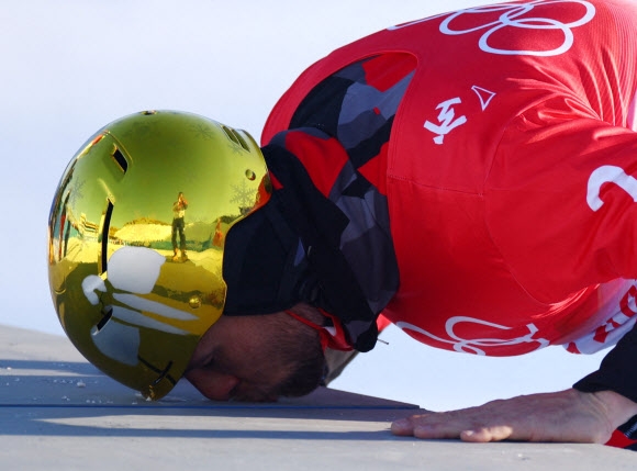 2022 베이징동계올림픽 중국 장자커우 젠팅 스노우 파크에서 열린 스노보드 남자 평행대회 결승에서 37살에 생애 첫 금메달을 따낸 오스트리아의 벤자민 칼이 시상대 단상에 입을 맞추고 있다. 로이터 연합뉴스 2022-02-08