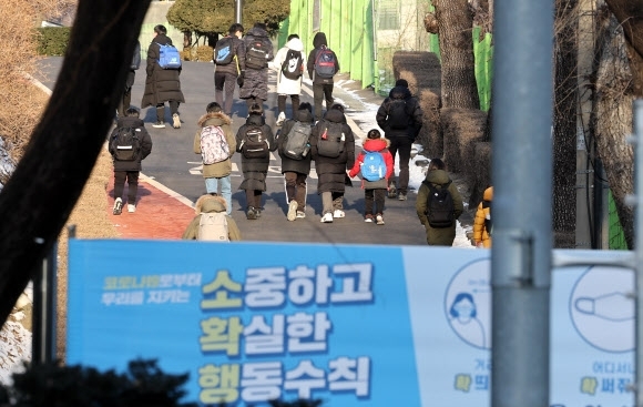 교육부의 새 학사운영 방안에 따르면, 밀접접촉자라도 백신접종 여부에 따라 등교 형태가 달라진다. 사진은 서울의 한 초등학교 학생들이 등교하고 있는 모습. 연합뉴스