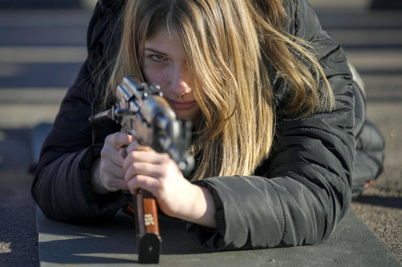 13일(현지시간) 우크라이나 동부 도네츠크주 마리우폴에서 한 여성이 우크라이나 국가방위군 산하 아조프 부대가 주관한 민간을 위한 기본 전투 훈련에 참가해 소총을 겨누고 있다. 마리우폴 AP 연합뉴스