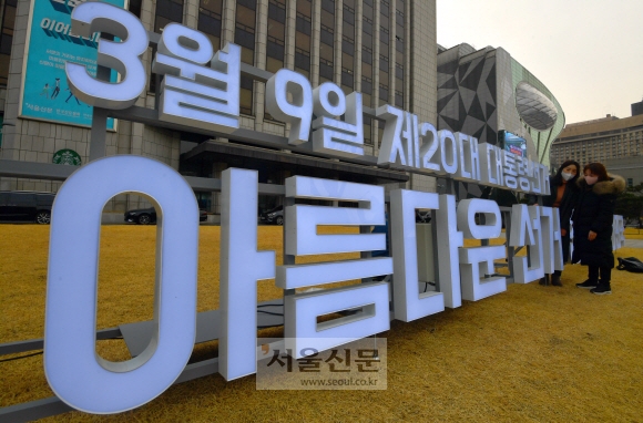 제20대 대선 공식 선거운동이 시작되기 하루 전인 14일 서울 중구 본사 서울마당에 설치된 투표 독려 홍보물을 시민들이 살펴보고 있다. 여론조사에서 박빙 승부를 벌이고 있는 이재명 더불어민주당 대선후보와 윤석열 국민의힘 대선후보는 15일 각각 부산과 서울에서 첫 일정을 시작하며 22일간의 유세에 돌입했다. 박지환 기자