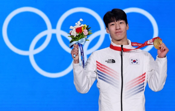 황대헌이 지난 10일 중국 베이징 메달 플라자에서 금메달과 꽃을 들고 기념 촬영하는 모습. 베이징 연합뉴스