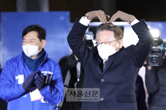 이재명(오른쪽) 더불어민주당 대선후보가 15일 서울 고속터미널역 앞 유세에서 두 팔로 하트 모양을 만들어 인사하고 있다.  정연호 기자