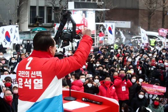 윤석열 국민의힘 후보가 당의 색깔(빨간색)과 기호가 들어간 점퍼를 입고 선거운동을 하고 있는 모습.