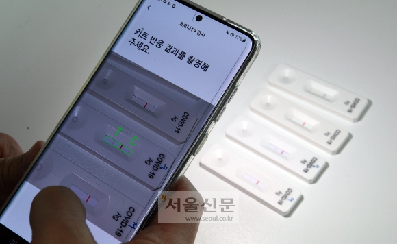지난 9일 서울 서초구 디아비전 사무실에서 이석용 대표가 코로나19 감염 여부를 확인하기 위해 디아비전 앱을 통해 검사를 마친 자가진단키트를 촬영하고 있다. 정연호 기자