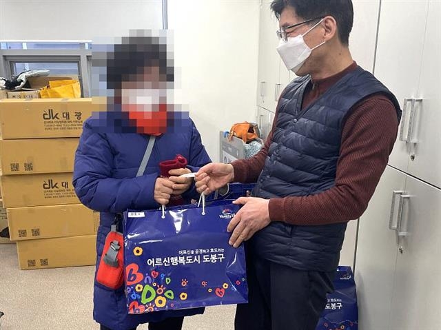 서울 도봉구 직원(오른쪽)이 지역 어르신에게 노인성 질환에 필요한 위생용품을 전달하고 있다. 도봉구 제공