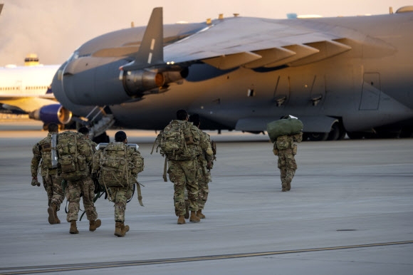 미국 제82 공수사단 요원들이 노스캐롤라이나주 포트 브래그에서 폴란드로의 배치에 앞서 활주로 위를 걷고 있다.  포트 브래그 AP 연합뉴스