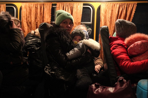 19일(현지시간) 우크라이나 도네츠크주의 친러 반군 지역인 도네츠크인민공화국(DPR)을 출발해 러시아 로스토프주 네클리놉스키 지역 크라스니데산트 마을에 마련된 난민촌에 도착한 버스에 어린아이를 안은 여성 등 피란민들이 타고 있다. 네클리놉스키 타스 연합뉴스
