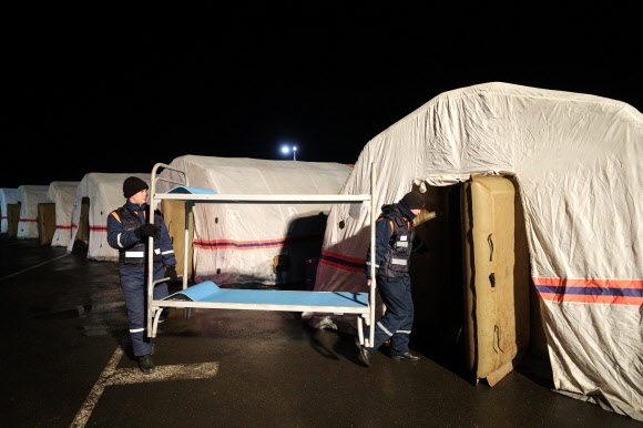 19일(현지시간) 러시아 비상상황부 직원들이 러시아 로스토프주 마트비예프쿠르간 국경검문소에 마련된 도네츠크인민공화국(DPR) 주민들을 위한 난민촌 텐트에 간이침대를 들여놓고 있다. 아빌로우스펜스카 타스 연합뉴스