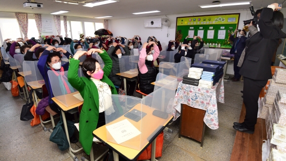 23일 오전 서울 마포구 일성여중고에서 열린 ‘만학도 졸업식’에서 졸업생들이 머리위로 하트를 그리고 있다. 2022. 2. 23 안주영 전문기자