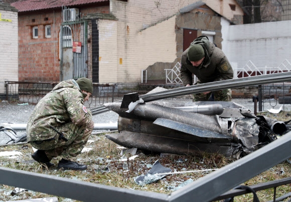 24일(현지시간) 우크라이나 수도 키이우 시내 거리에 떨어진 미사일 잔해를 경찰이 조사하고 있다. 블라디미르 푸틴 러시아 대통령이 이날 동부 우크라이나 지역에서의 군사작전을 승인해 러시아군의 우크라이나 침공이 시작됐다. 2022.2.24 키이우 로이터 연합뉴스