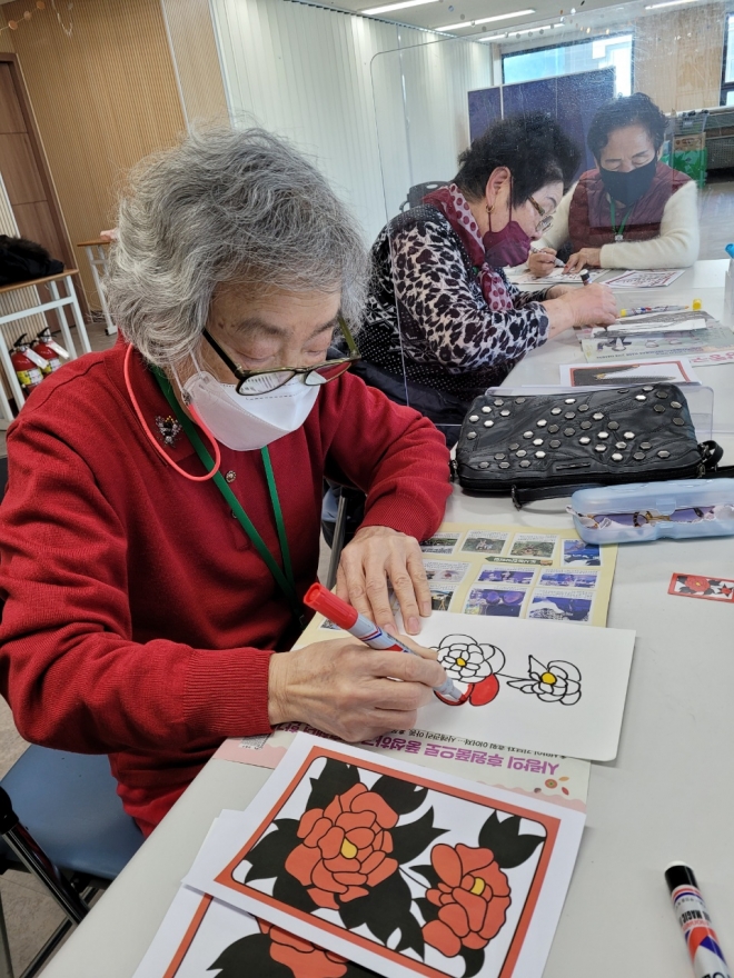 ‘신이어마켙’  프로젝트 노인들 ‘신이어마켙’ 프로젝트에 참여한 할머니들이 화투를 그리고 있다. 신융아 기자