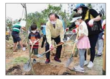 유동균(가운데) 마포구청장이 마포구의 대표적인 친환경 정책인‘500만 그루 나무 심기’ 행사에 참여한 어린이들과 함께 나무를 심고 있다. 마포구 제공 