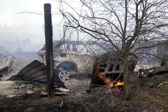 2022년 2월 24일 우크라이나 키예프 외곽에서 러시아군의 포격 후 불이 난 자동차와 프리벳의 잔해 풍경. 러시아는 24일(현지시간) 우크라이나 전역의 시설들에 대해 공습을 가했다. AP 연합뉴스