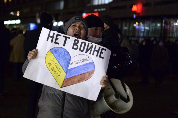 24일(현지시간) 러시아 모스크바에서 열린 우크라이나 침공 반대 시위 참가자가 “전쟁 반대”가 적힌 포스터를 들고 있다. 우크라이나와 러시아 국기가 하트 모양 그림 안에 나란히 그려진 모습이 인상적이다. 모스크바 AP 연합뉴스