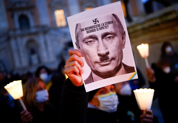 25일(현지시간) 이탈리아 로마에서 반전 및 우크라이나 연대 시위에서도 나치 독일의 독재자 히틀러와 블라디미르 푸틴 러시아 대통령을 합친 사진이 등장했다. 로마 로이터 연합뉴스