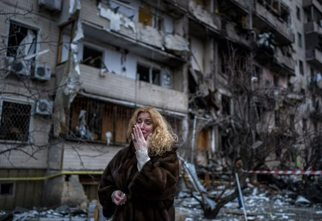 우크라이나 수도 키이우의 한 주민이 러시아의 로켓포 공격으로 초토화 된 자신의 아파트 앞에서 눈물을 감추지 못하고 있다. AP 연합뉴스